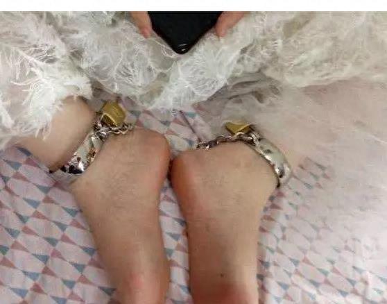 婚礼当天新娘穿着婚纱双脚被脚镣锁住，脸上却洋溢着幸福的笑容